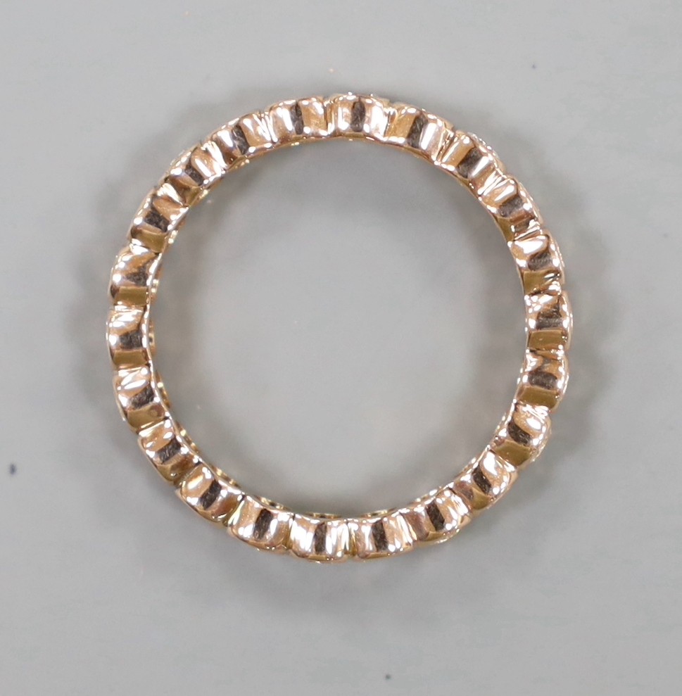 A yellow metal and diamond set full eternity ring, size N, gross weight 2.4 grams.